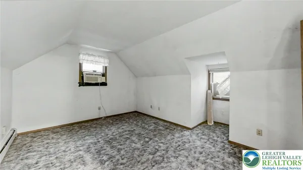a view of a room with wooden floor and white walls