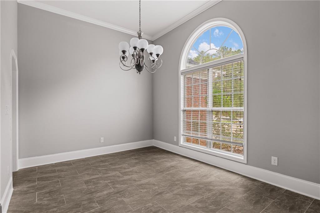 1449 Cummings Road Smiths Station, AL 36877 - Photo 4 of 28 Arched window with blinds, tile flooring, crown molding, and a chandelier