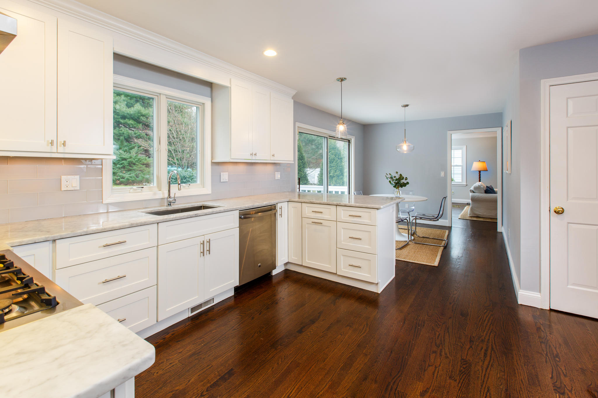 49 Country Club Road Darien, CT 06820 - Photo 11 of 30 a kitchen with stainless steel appliances wooden floors and white cabinets
