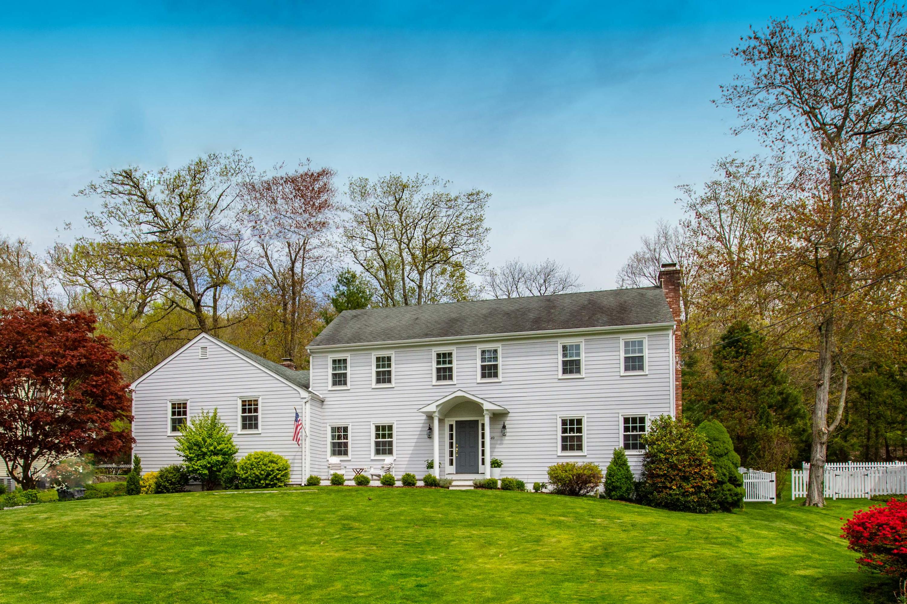49 Country Club Road Darien, CT 06820 - Photo 2 of 30 a front view of a house with a garden and trees