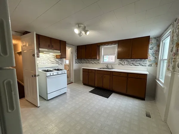 a kitchen with stainless steel appliances kitchen island granite countertop a stove refrigerator and cabinets