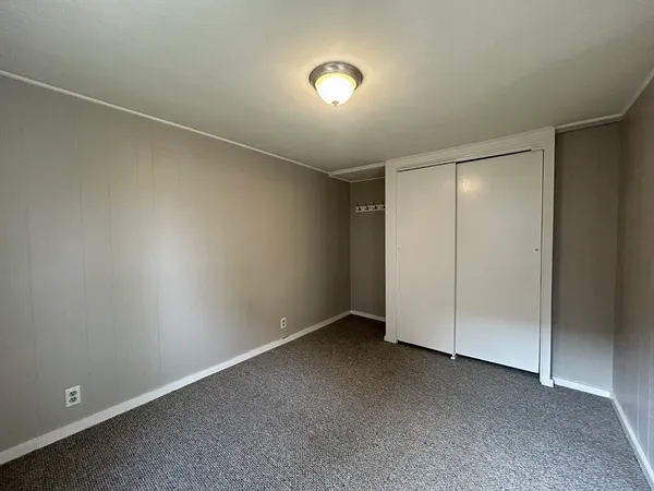 an empty room with closet and wooden floor