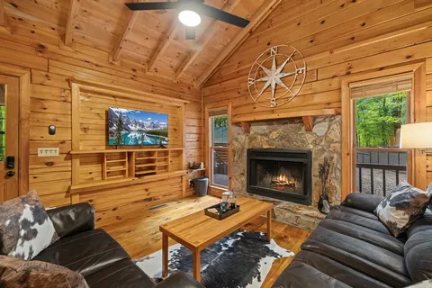 a living room with furniture a flat screen tv and a fireplace