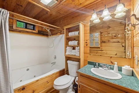 a bathroom with a granite countertop sink toilet a mirror and shower