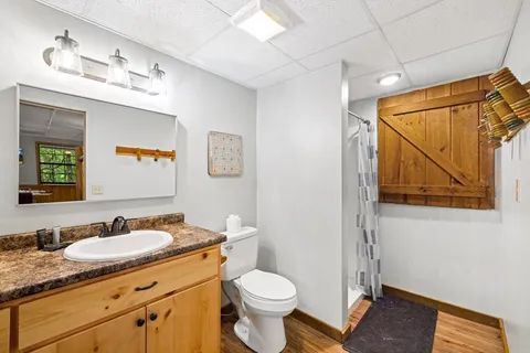a bathroom with a granite countertop sink toilet and shower