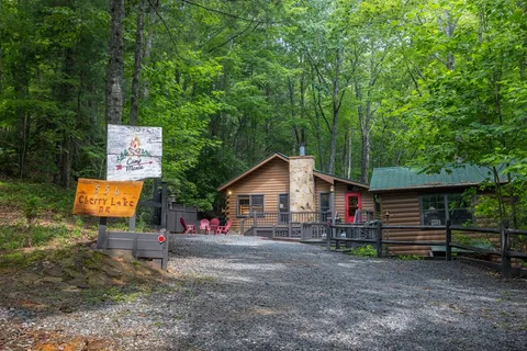 a dirt road with wooden fence and trees