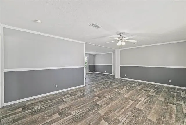 a view of an empty room with a chandelier fan