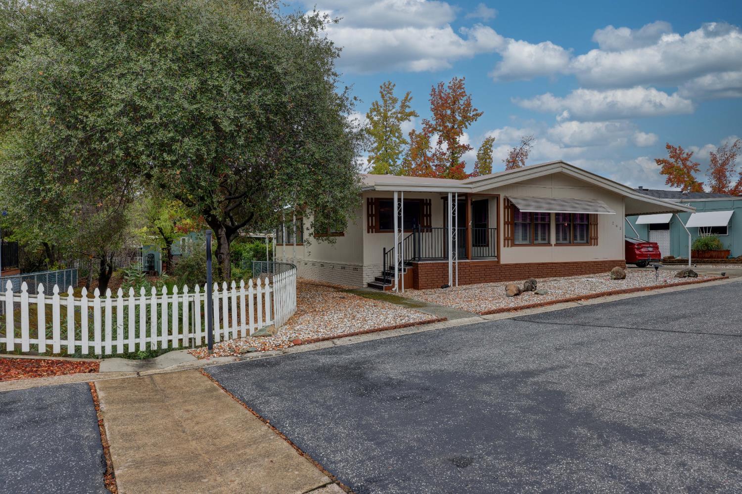 a front view of a house with a garden and trees