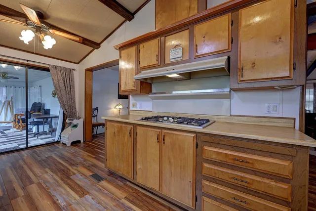 a kitchen with a window wooden floor and stainless steel appliances