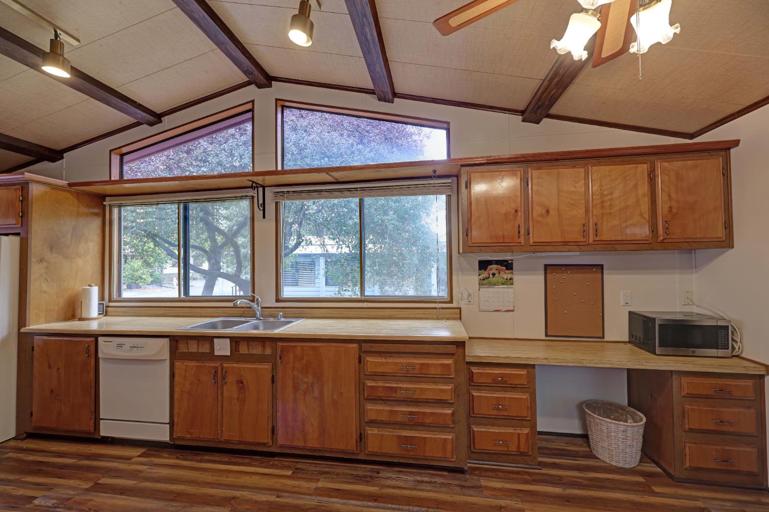 3765 Grass Valley Highway, Unit 263 Auburn, CA 95602 - Photo 17 of 38 a kitchen with a window wooden floor and stainless steel appliances