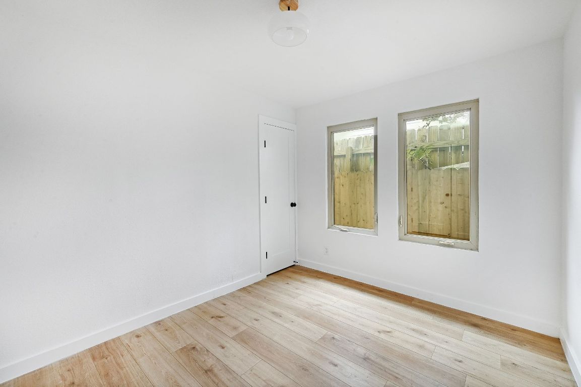 2404 Santa Rita Street Austin, TX 78702 - Photo 15 of 27 Empty room with light wood finished floors and baseboards