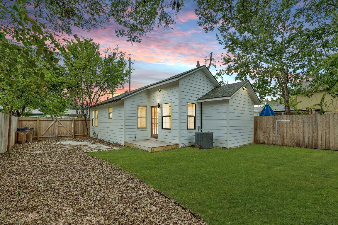 2404 Santa Rita Street Austin, TX 78702 - Photo 20 of 27 Back of house at dusk featuring a fenced backyard and a gate