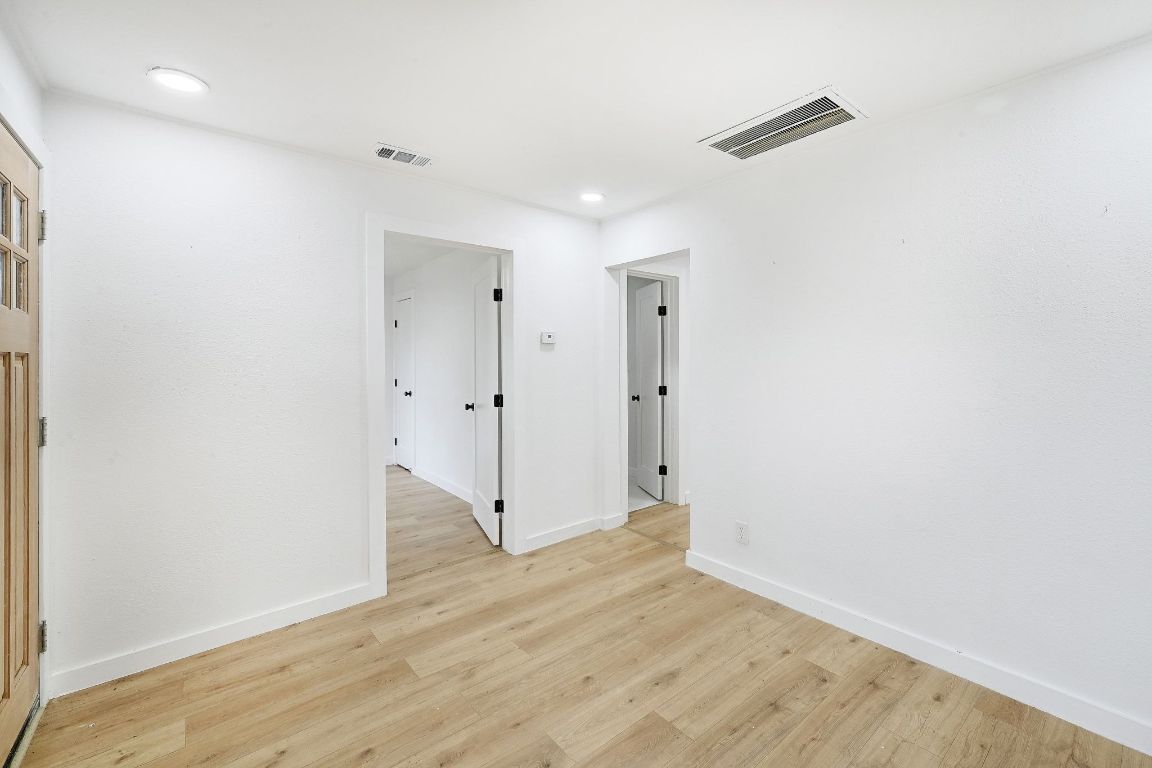 2404 Santa Rita Street Austin, TX 78702 - Photo 6 of 27 Spare room featuring light wood-style floors and recessed lighting