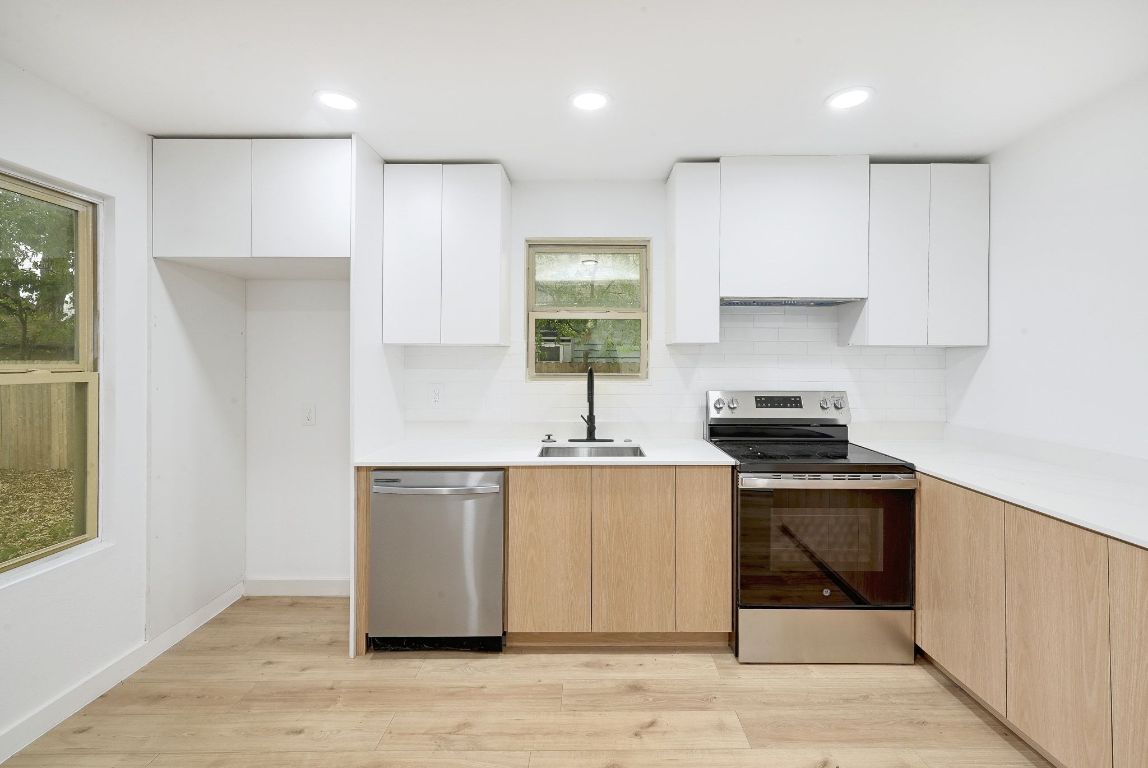 2404 Santa Rita Street Austin, TX 78702 - Photo 10 of 27 Kitchen featuring modern cabinets, stainless steel appliances, white cabinetry, and recessed lighting
