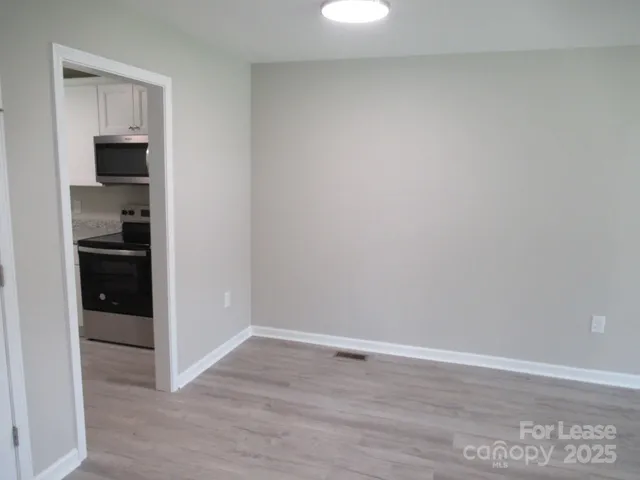 a view of kitchen and hallway with wooden floor