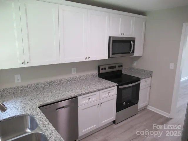 a kitchen with stainless steel appliances granite countertop a sink and a microwave