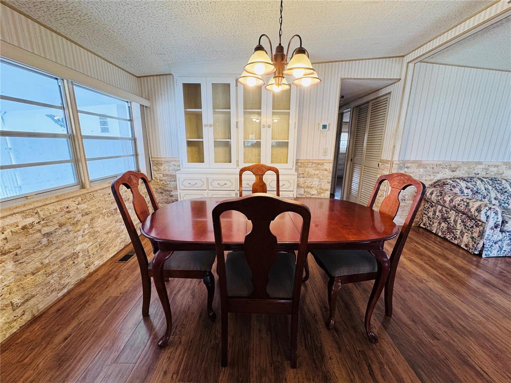2331 Belleair Road, Unit 715 Clearwater, FL 33764 - Photo 12 of 43 a view of a dining room with furniture wooden floor and chandelier