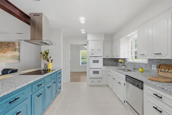 a kitchen with kitchen island granite countertop sink cabinets and stainless steel appliances