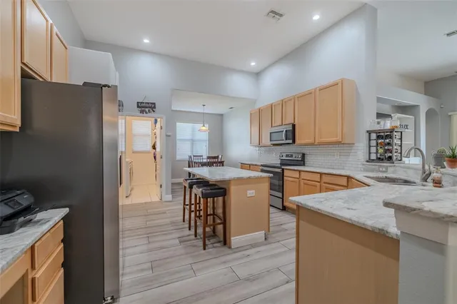 a kitchen with granite countertop a refrigerator stove top oven and sink