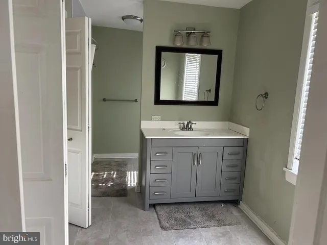 a bathroom with a sink vanity and mirror