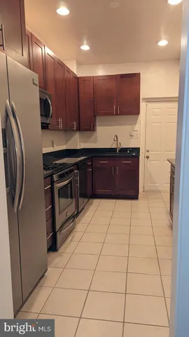 a kitchen with stainless steel appliances granite countertop a refrigerator a stove and a wooden floors