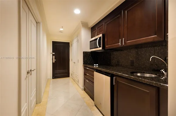 a kitchen with stainless steel appliances granite countertop a refrigerator and a stove top oven
