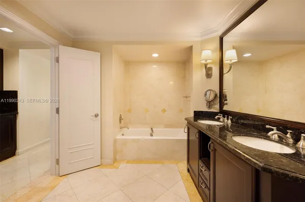 a spacious bathroom with a granite countertop sink a mirror and a bathtub