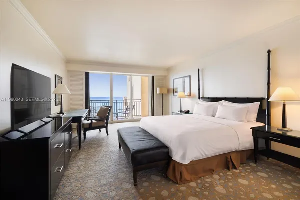a spacious bedroom with a bed and a flat screen tv