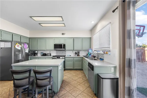 a kitchen with a sink a stove and chairs