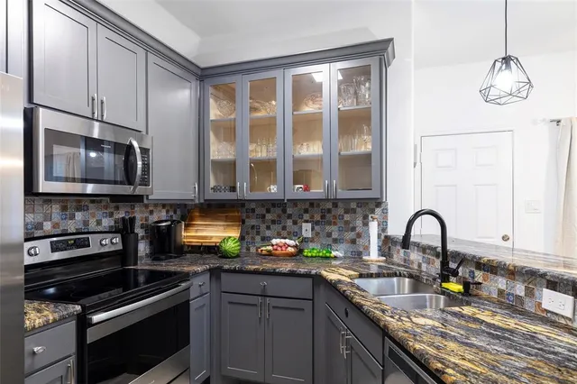 a kitchen with stainless steel appliances granite countertop a stove a sink and a microwave
