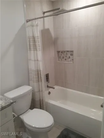 a white toilet sitting next to a bath tub and a shower