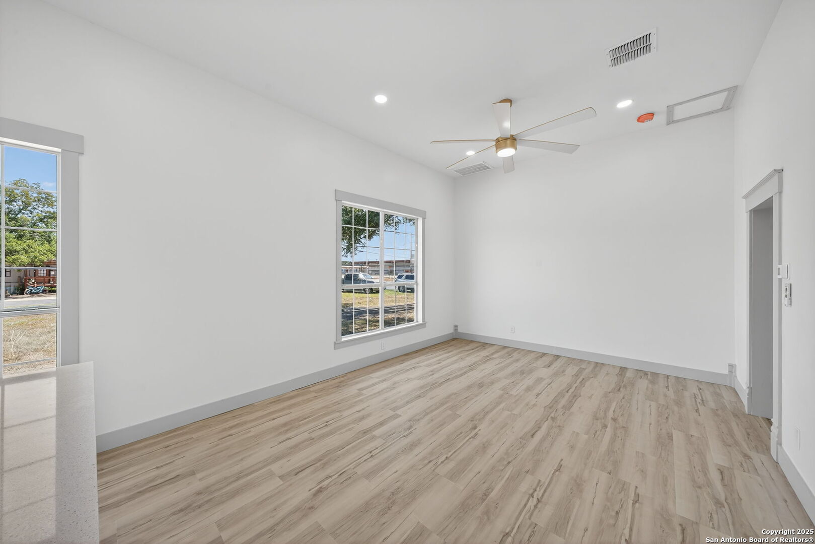904 17th Street Hondo, TX 78861 - Photo 14 of 31 an empty room with wooden floor ceiling fan and windows