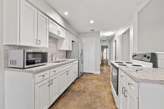 a kitchen with stainless steel appliances granite countertop a stove a sink and a refrigerator