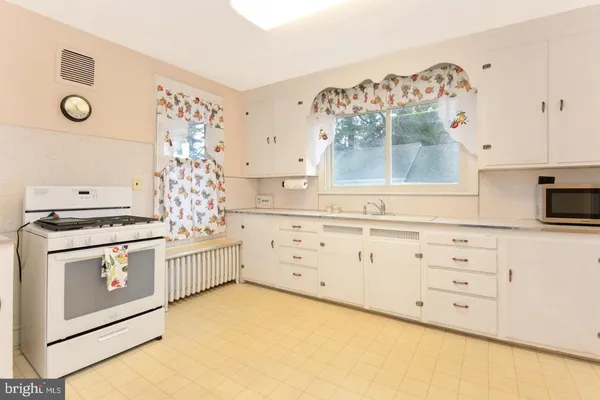 a kitchen with white cabinets and white appliances