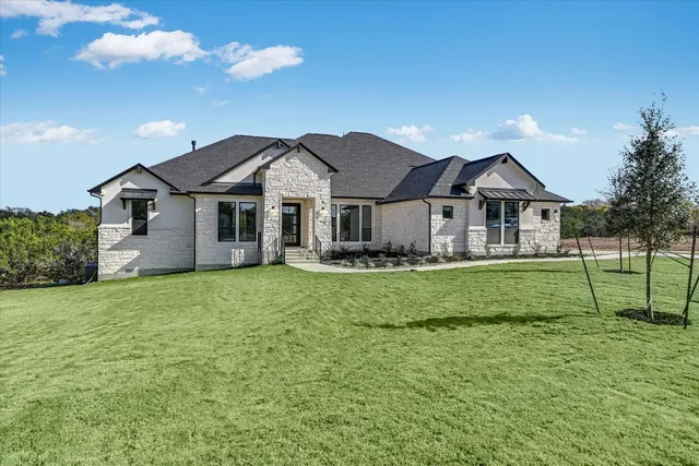 a front view of a house with a garden