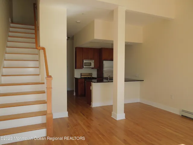 a view of entryway and hall with wooden floor