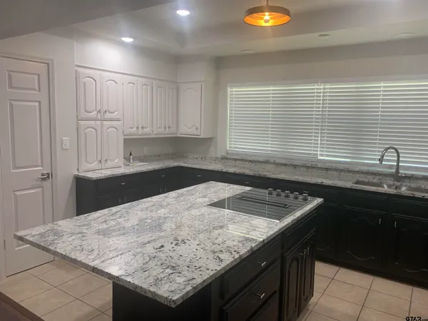 a kitchen with granite countertop a sink a stove and cabinets