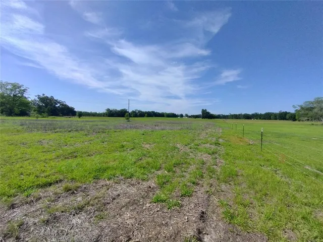 a view of a field with ocean in the background