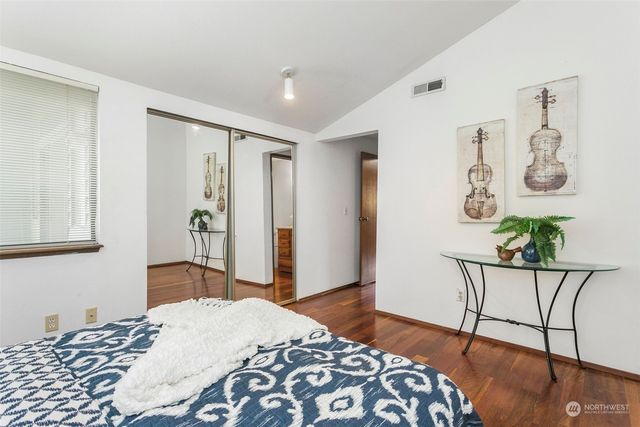 a bedroom with a bed and painting on the wall