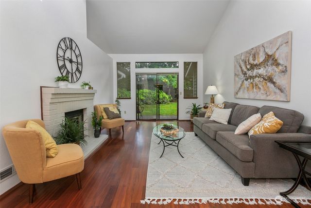 a living room with furniture a fireplace and a large mirror next to a window