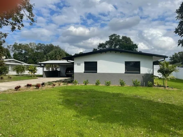 a view of a house with backyard sitting area and garden