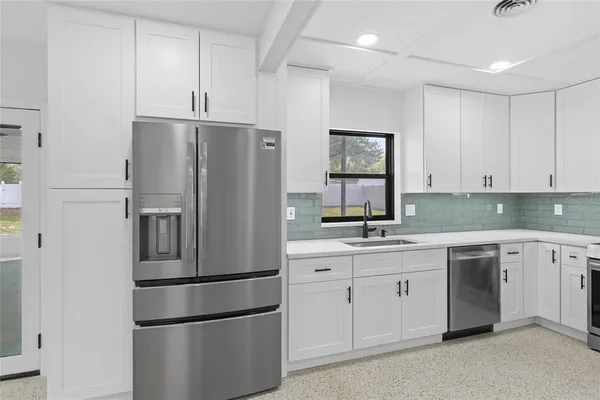 a kitchen with stainless steel appliances a refrigerator sink and cabinets
