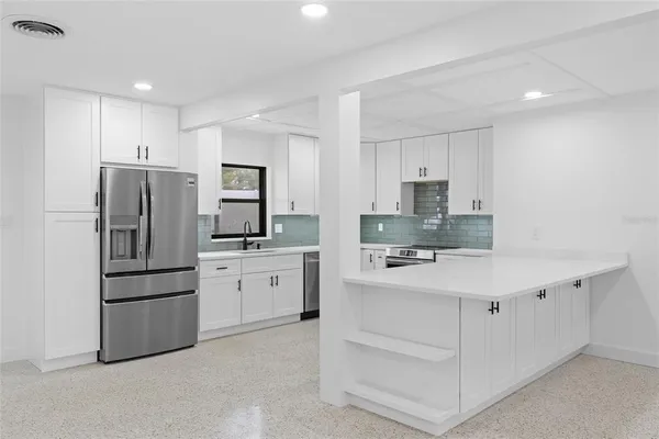 a kitchen with white cabinets and stainless steel appliances