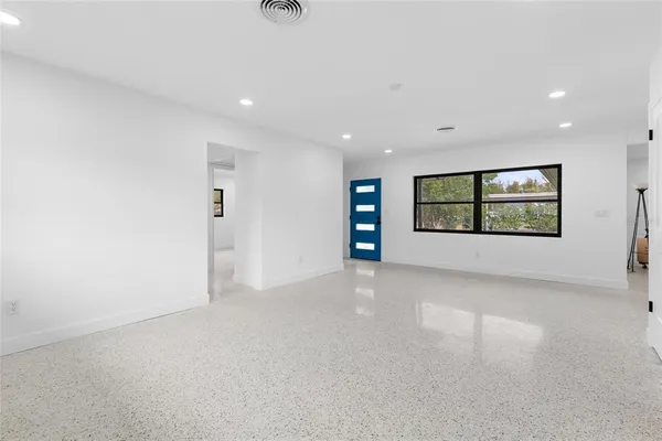 an empty room with windows and mirror