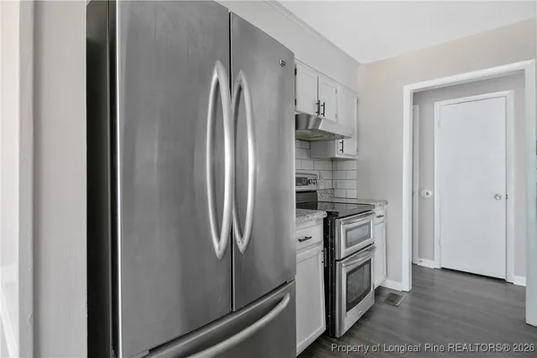 a kitchen with granite countertop white cabinets and a sink