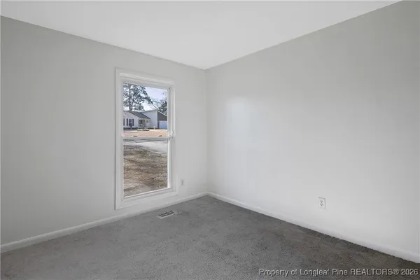 an empty room with a window and a fan