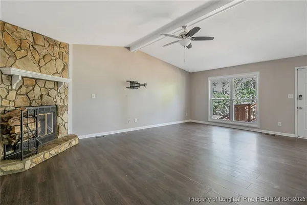 a view of an empty room with a window and fireplace