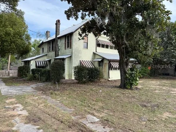 a view of a house with a tree and a yard