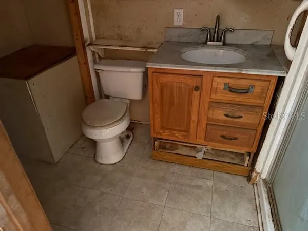 a bathroom with a granite countertop toilet and a sink
