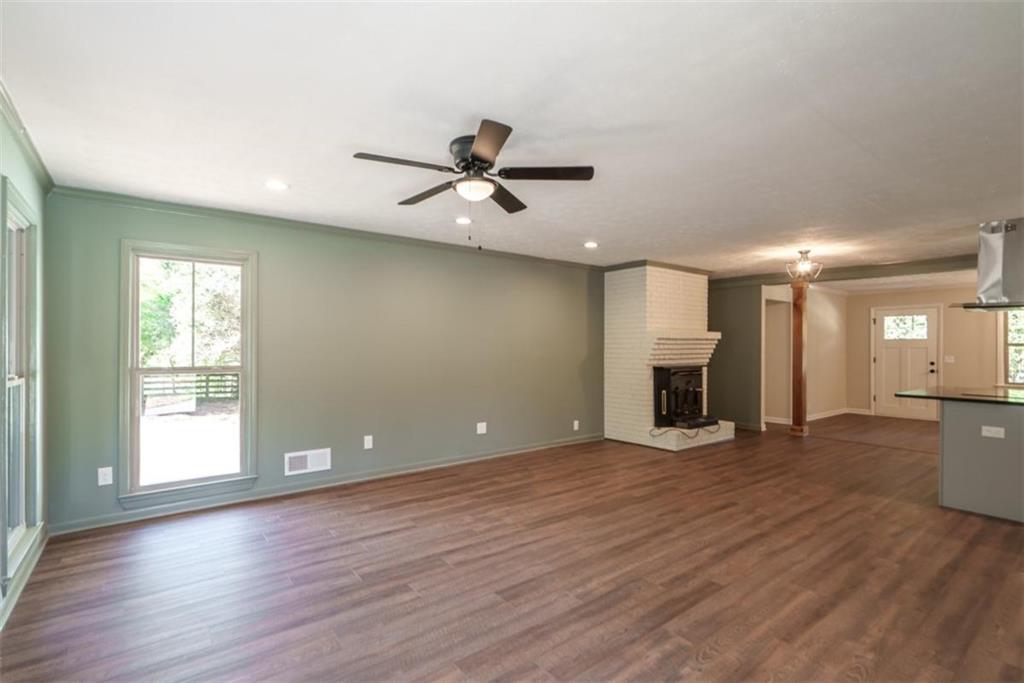 2635 Preston Road Good Hope, GA 30641 - Photo 13 of 68 a view of a livingroom with a fireplace a ceiling fan and wooden floor